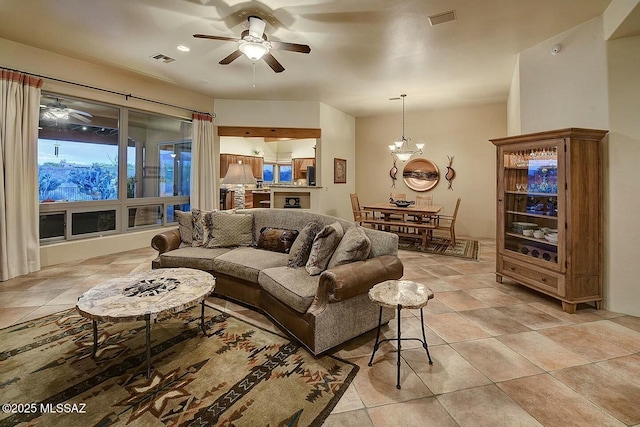 living area featuring visible vents and ceiling fan with notable chandelier