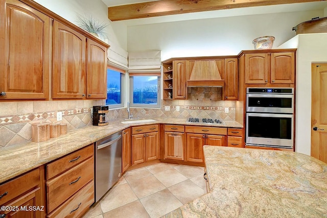 kitchen with stainless steel appliances, a sink, light stone counters, custom range hood, and light tile patterned floors
