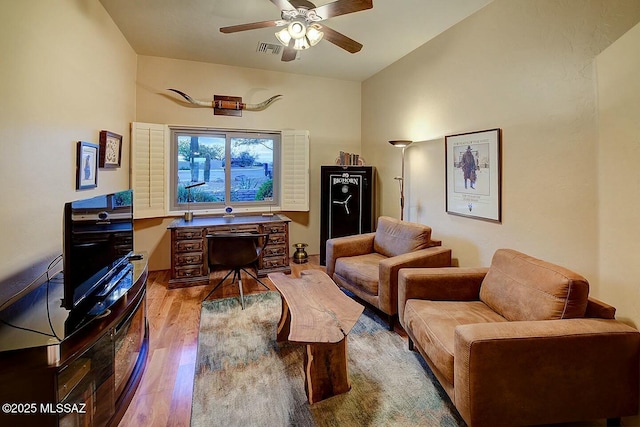 interior space featuring wood finished floors, visible vents, lofted ceiling, and ceiling fan