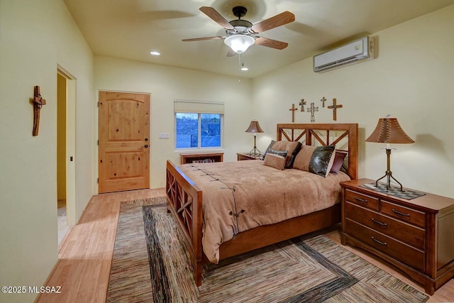 bedroom with recessed lighting, a wall mounted AC, light wood-style flooring, and ceiling fan