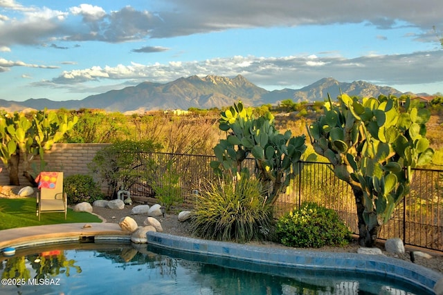 view of pool featuring fence, a fenced in pool, and a mountain view