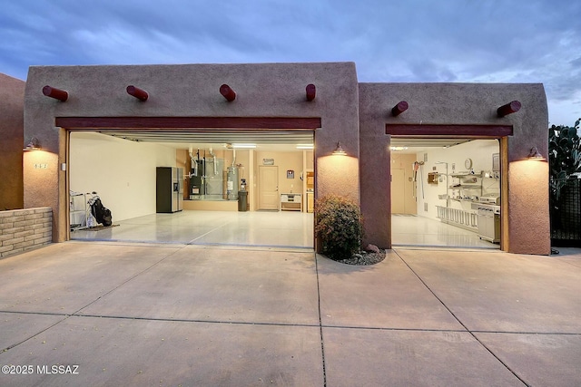 garage with water heater and concrete driveway