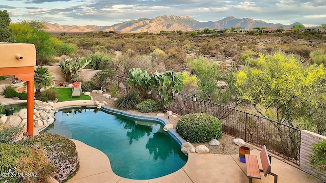 view of pool featuring a fenced in pool, a patio area, a fenced backyard, and a mountain view