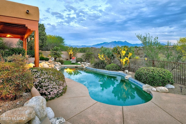 view of swimming pool featuring a fenced in pool, a fenced backyard, and a mountain view