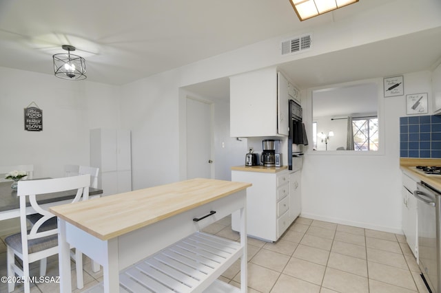kitchen with white cabinetry, visible vents, stainless steel dishwasher, and light tile patterned floors