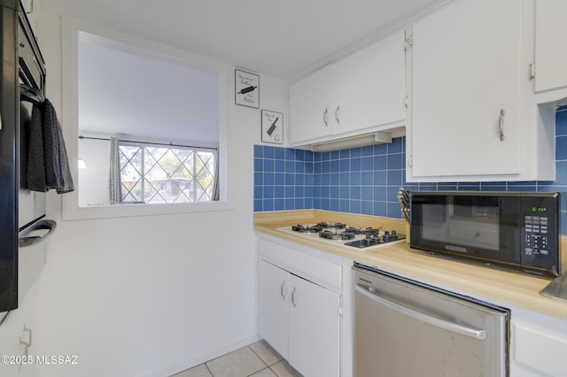 kitchen with light countertops, white gas stovetop, stainless steel dishwasher, black microwave, and backsplash