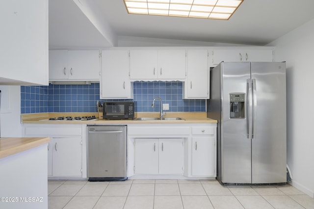 kitchen with light countertops, a sink, tasteful backsplash, and appliances with stainless steel finishes