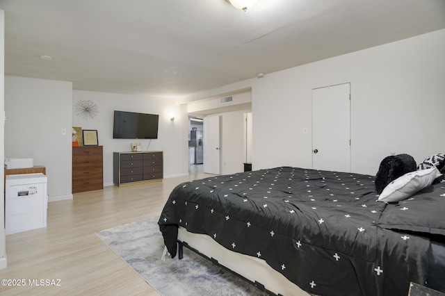 bedroom with wood finished floors, baseboards, and visible vents