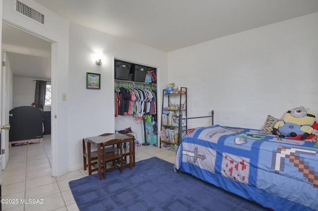 bedroom with a closet, visible vents, and tile patterned flooring