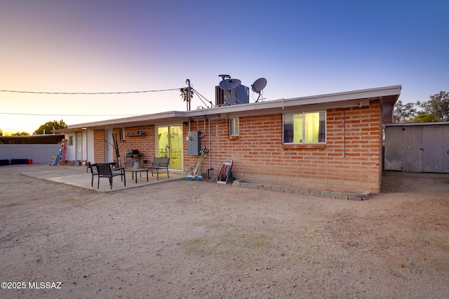 back of house with a patio and brick siding