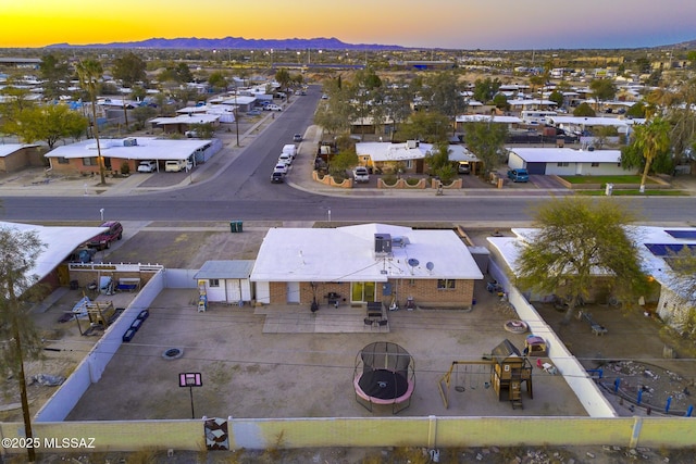 aerial view at dusk featuring a residential view and a mountain view