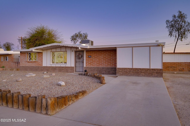 view of front of house featuring brick siding and fence