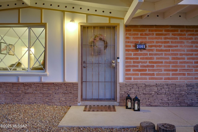 property entrance with stone siding and brick siding