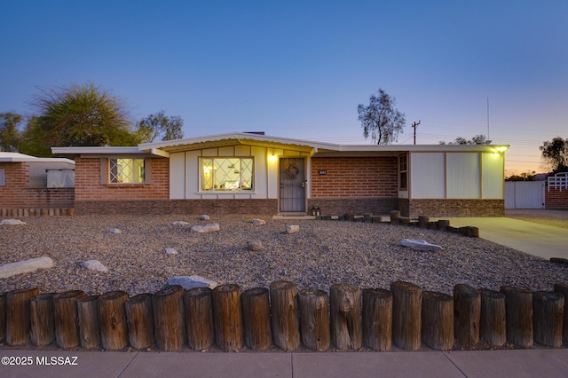 view of front of property featuring brick siding and a fenced front yard
