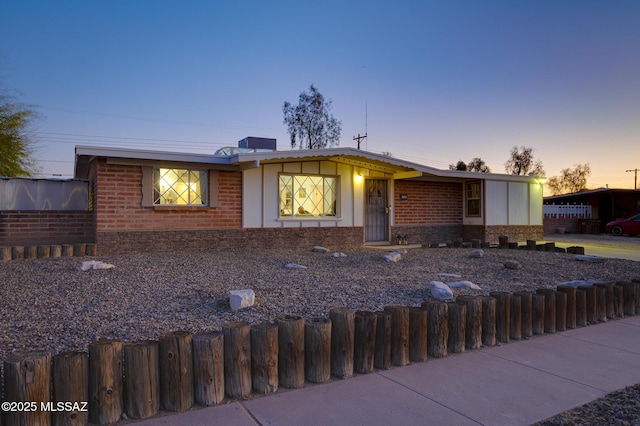 view of front of property with a fenced front yard and brick siding