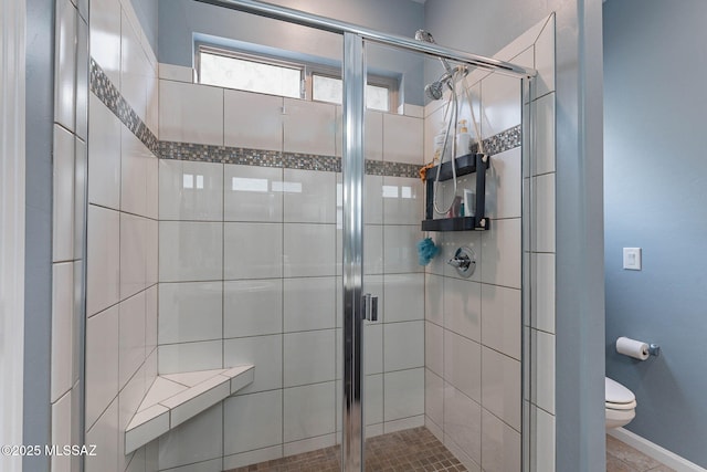 full bath with baseboards, toilet, and a shower stall
