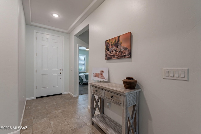 foyer entrance with light tile patterned flooring and baseboards