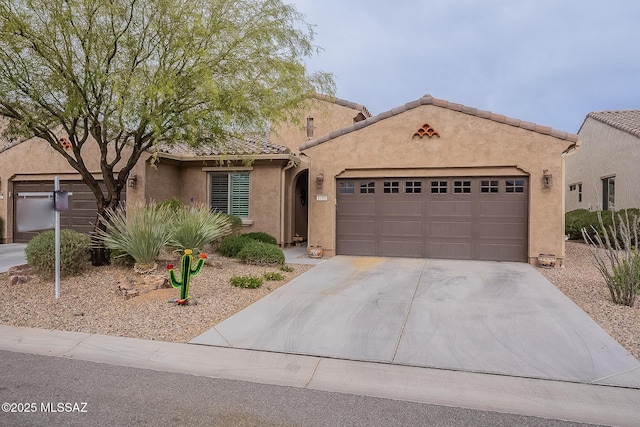 view of front facade with stucco siding, a garage, a tiled roof, and concrete driveway