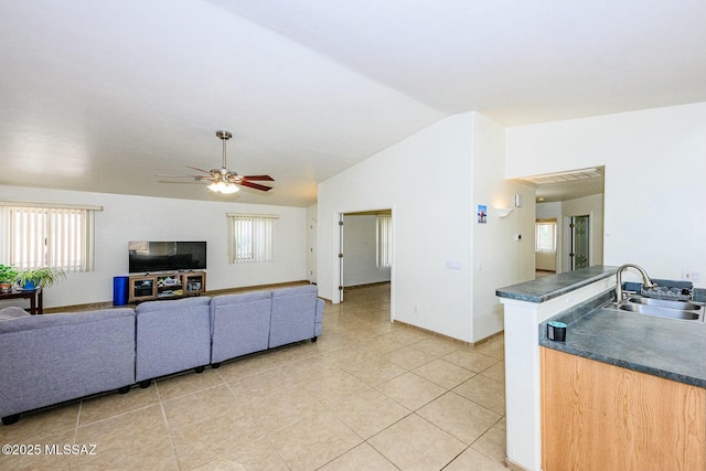 living room featuring light tile patterned flooring, lofted ceiling, baseboards, and a ceiling fan