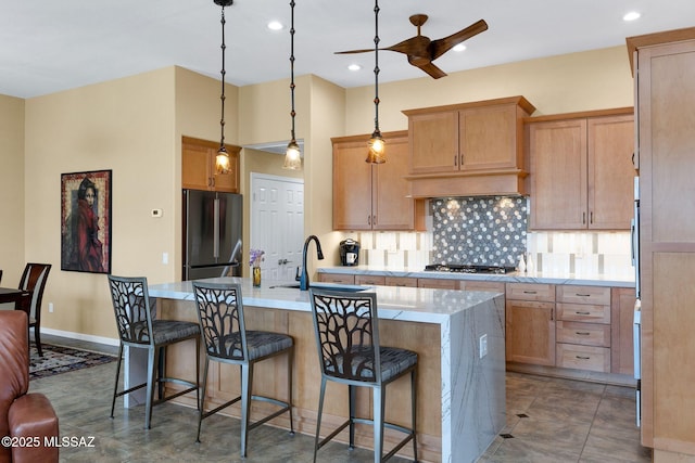 39425 S Mchaney Ct, Tucson, AZ 85739 - kitchen featuring decorative backsplash, a sink, an island with sink, a ceiling fan, and appliances with stainless steel finishes