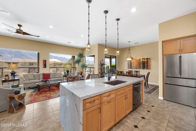 39425 S Mchaney Ct, Tucson, AZ 85739 - kitchen featuring an island with sink, stainless steel refrigerator, light stone counters, a sink, and black dishwasher