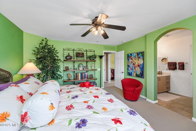39425 S Mchaney Ct, Tucson, AZ 85739 - carpeted bedroom with baseboards, arched walkways, connected bathroom, ceiling fan, and visible vents