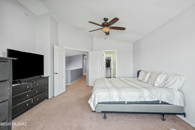 carpeted bedroom with ceiling fan, visible vents, vaulted ceiling, and a walk in closet