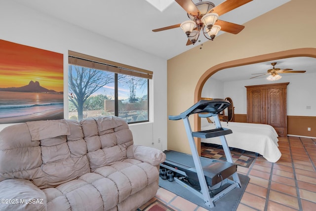 interior space featuring a wainscoted wall and a ceiling fan