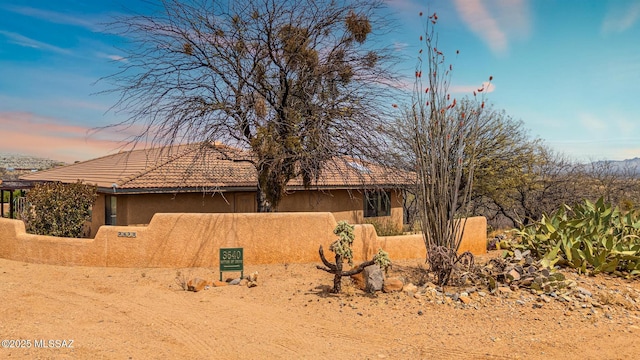 view of front of house featuring stucco siding and a tile roof