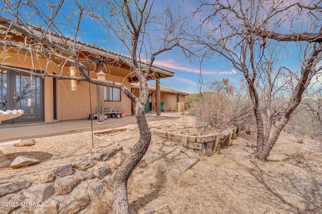 rear view of property with a patio area and stucco siding