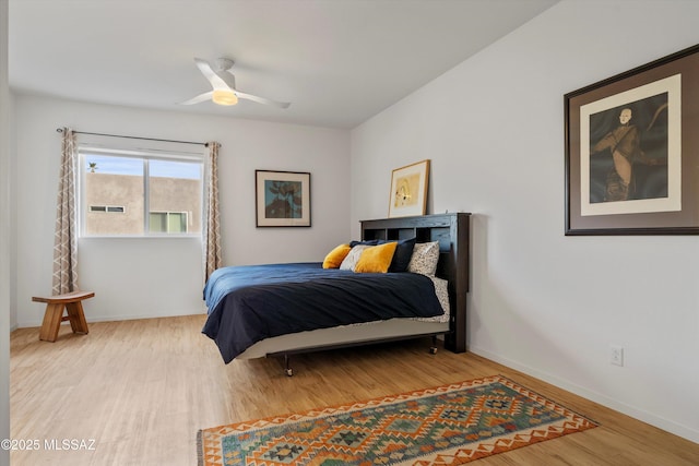 bedroom with a ceiling fan, baseboards, and wood finished floors