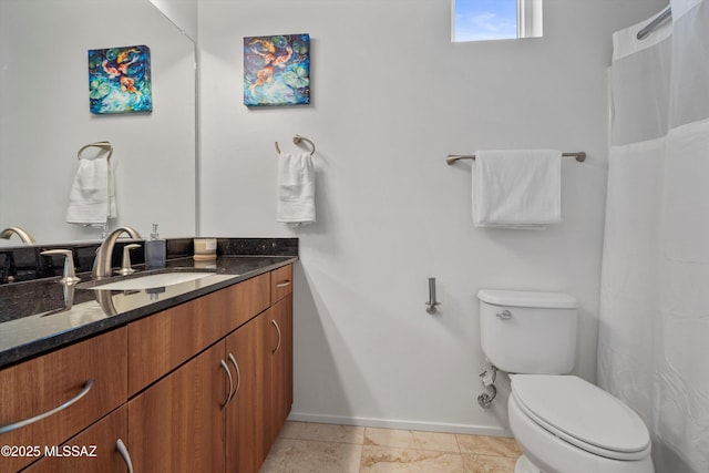 bathroom featuring baseboards, toilet, and vanity