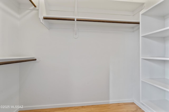 walk in closet with wood finished floors