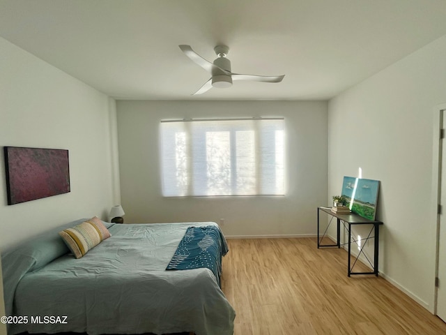 bedroom with baseboards, a ceiling fan, and light wood-type flooring