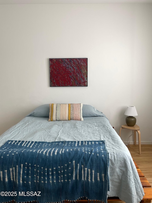 bedroom featuring baseboards and wood finished floors