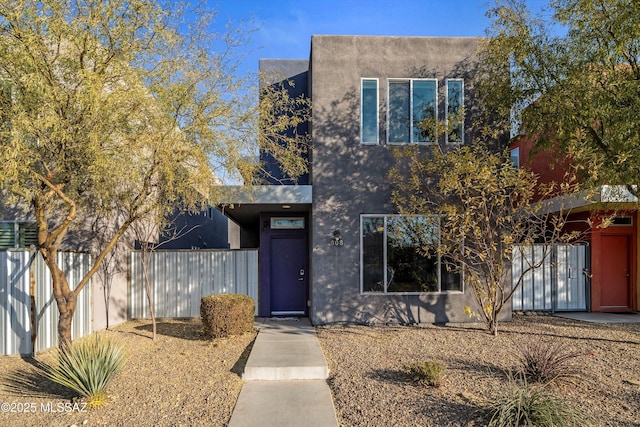 view of front of home featuring stucco siding and fence
