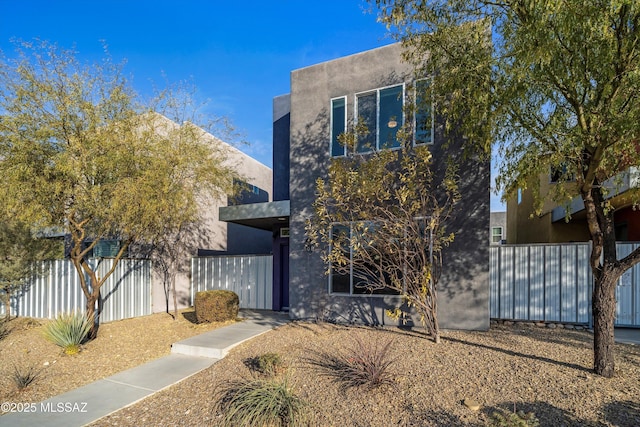 view of front of house with stucco siding and fence