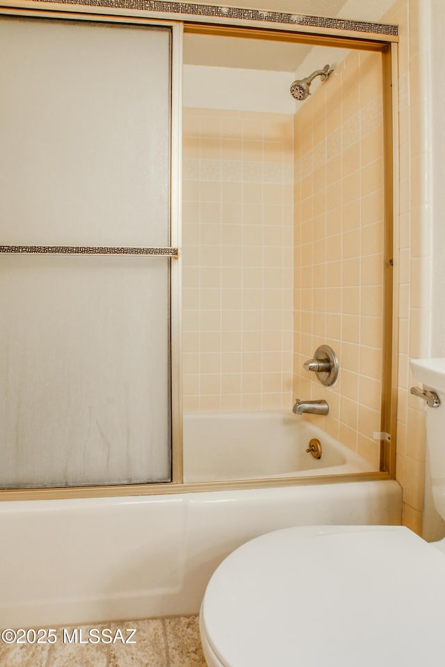 full bath featuring toilet and bath / shower combo with glass door