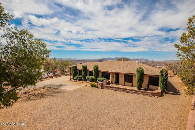 view of front of home with stucco siding, a mountain view, and concrete driveway