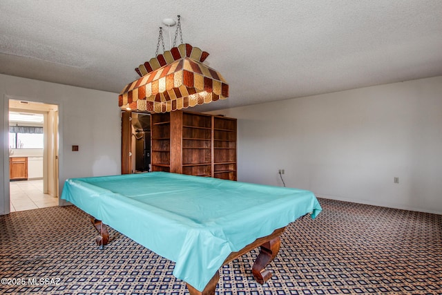 game room with billiards, a textured ceiling, and light carpet