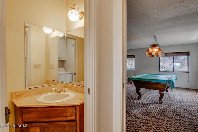 bathroom with pool table, vanity, a textured ceiling, and washer and clothes dryer