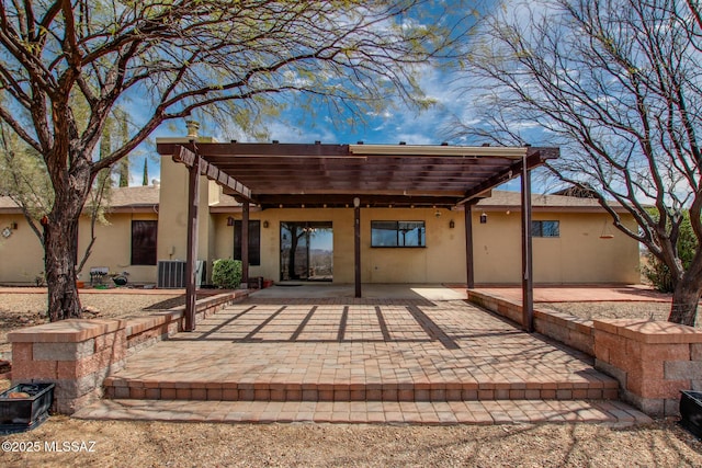 back of house with a pergola, stucco siding, and a patio area