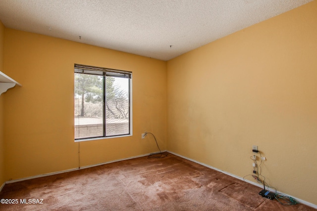 carpeted empty room with a textured ceiling