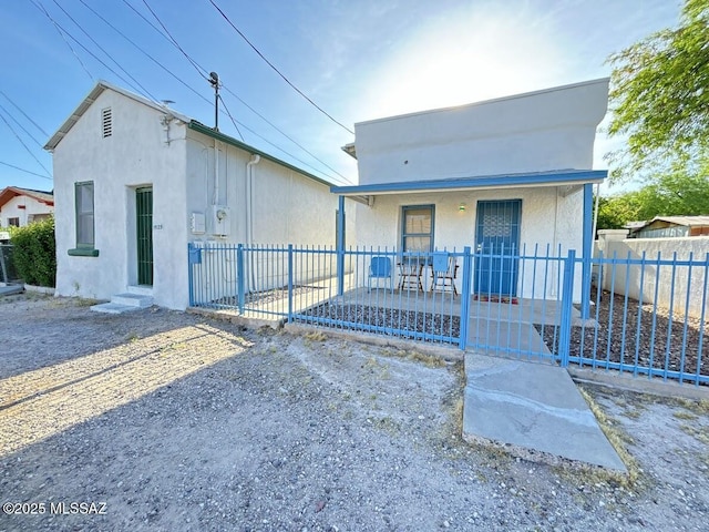 view of front of property with a porch, stucco siding, and fence