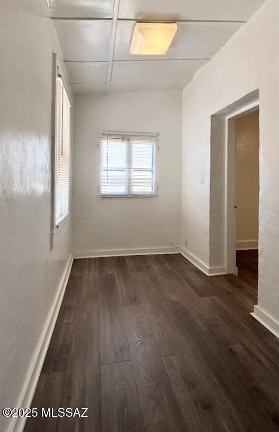empty room with dark wood-style flooring and baseboards