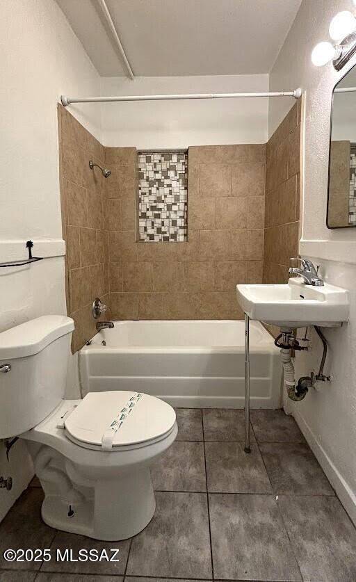 bathroom with toilet, a sink, shower / bath combination, and tile patterned floors