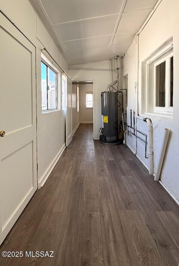 interior space with water heater, baseboards, and dark wood-style flooring