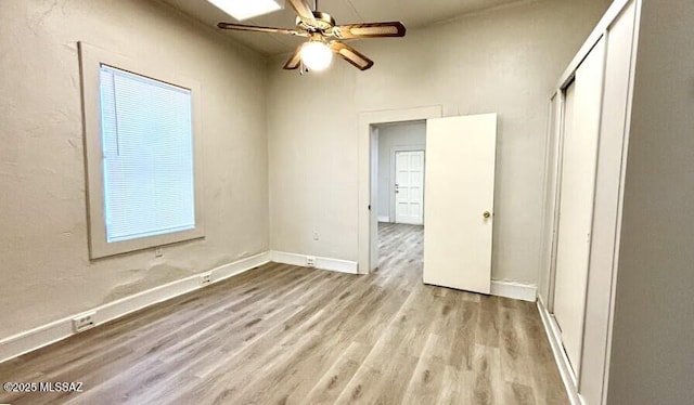 unfurnished bedroom with a ceiling fan, baseboards, a closet, and wood finished floors