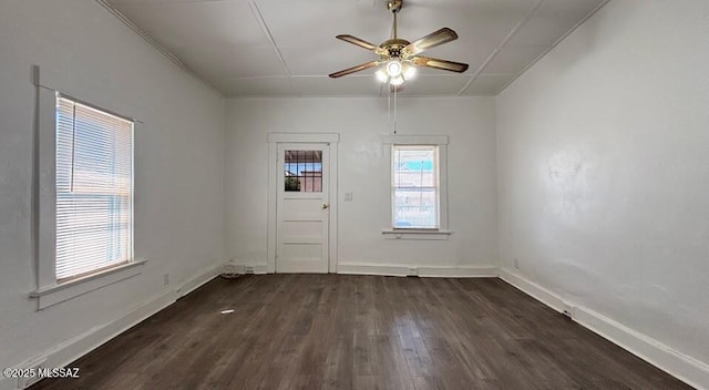 spare room with baseboards, a ceiling fan, and dark wood finished floors