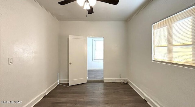spare room featuring baseboards, dark wood-style floors, and ceiling fan